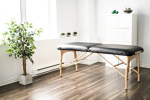 A physiotherapy room with table on wood flooring